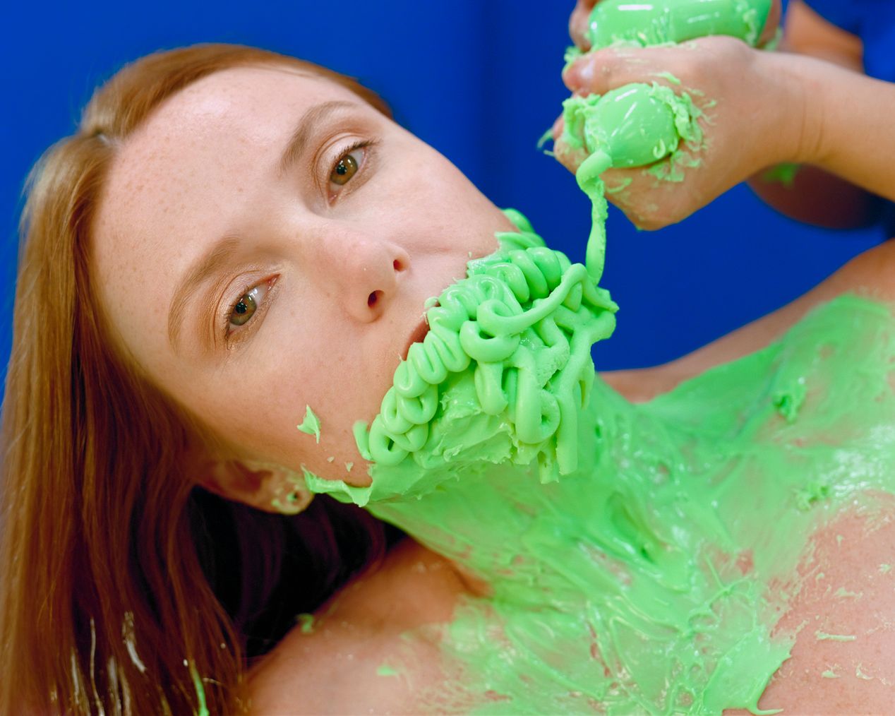 The artist is applying green silicone to the model's lips, art photography, Ilona Szwarc, contemporary Los Angeles artist.
