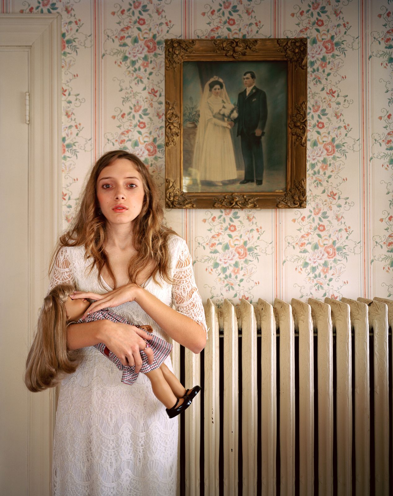 A young girl closing her doll's eyes, environmental portrait photography, Ilona Szwarc, contemporary Los Angeles artist.