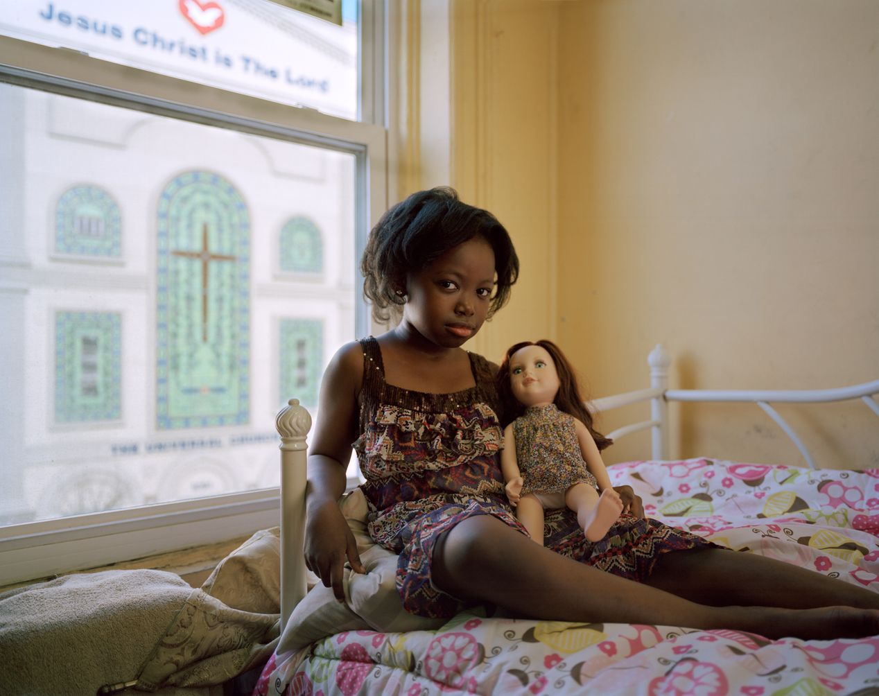 A young black girl holding a white doll, environmental portrait photography, Ilona Szwarc, contemporary Los Angeles artist.