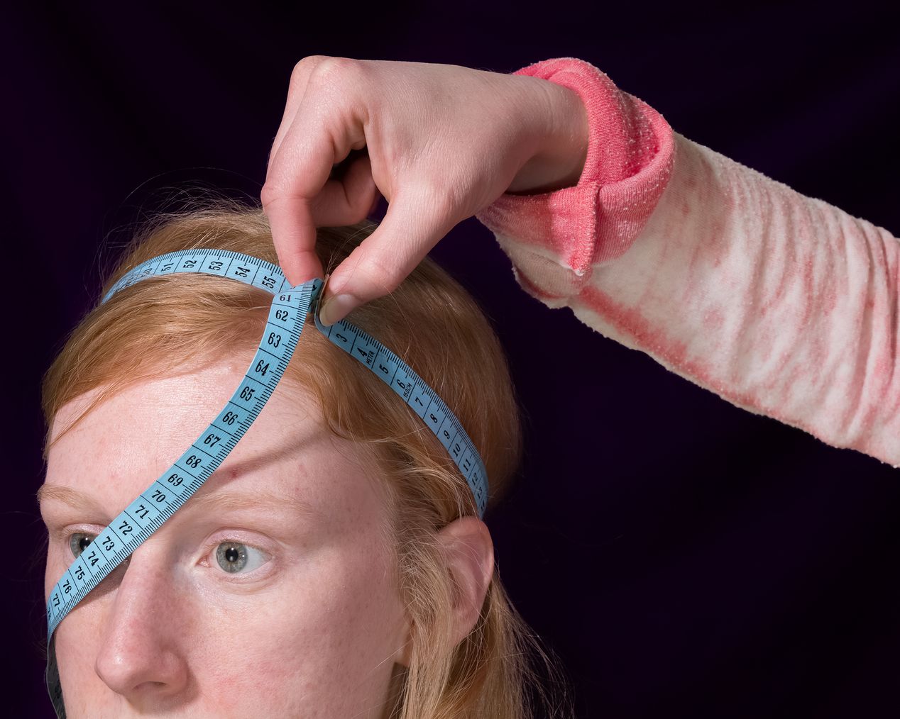 A hand hold a measuring tape across a woman's head, art photography, Ilona Szwarc, contemporary Los Angeles artist.