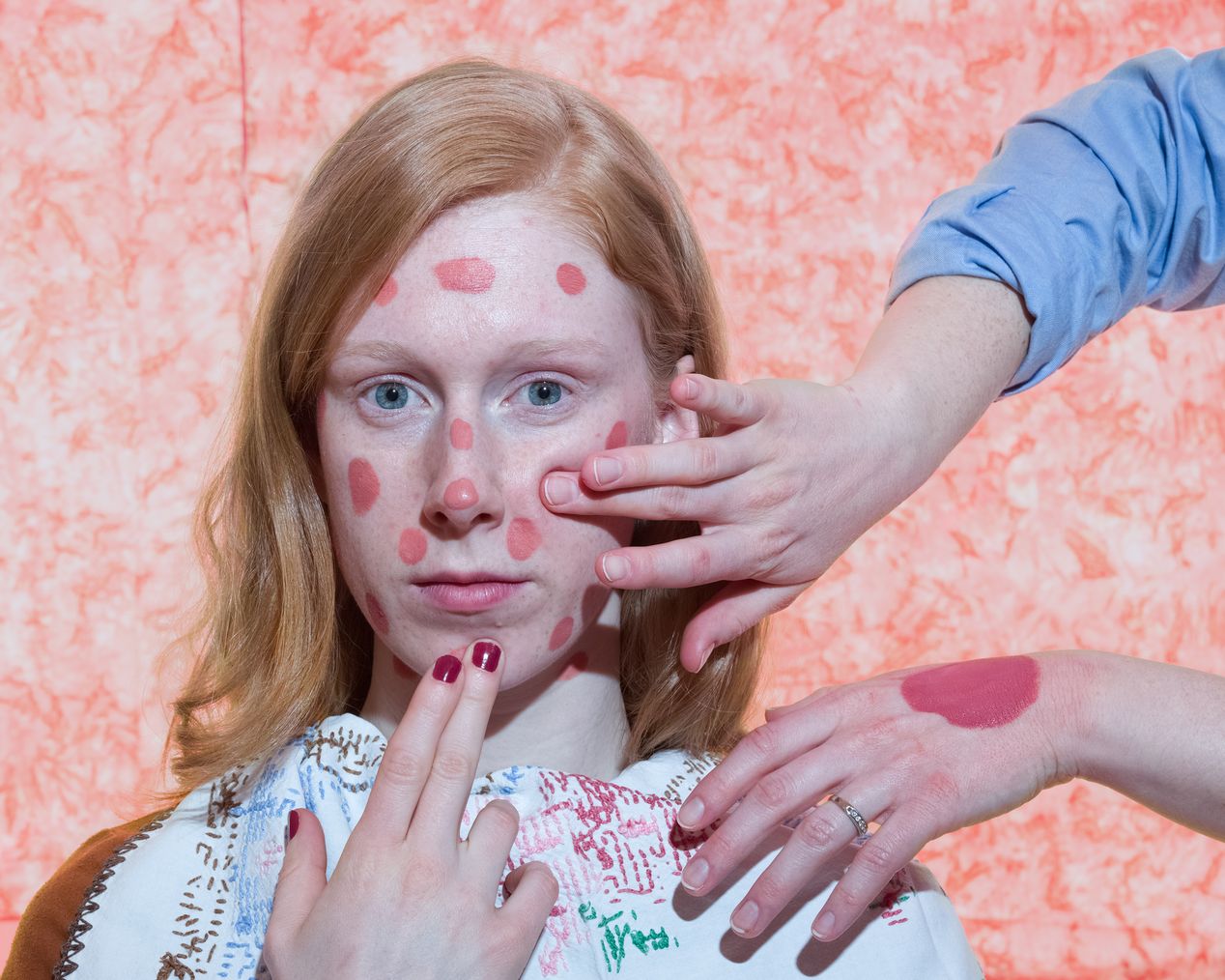 Makeup artist is applying pink dots of paint on a model's face, art photography, Ilona Szwarc, contemporary Los Angeles artist.