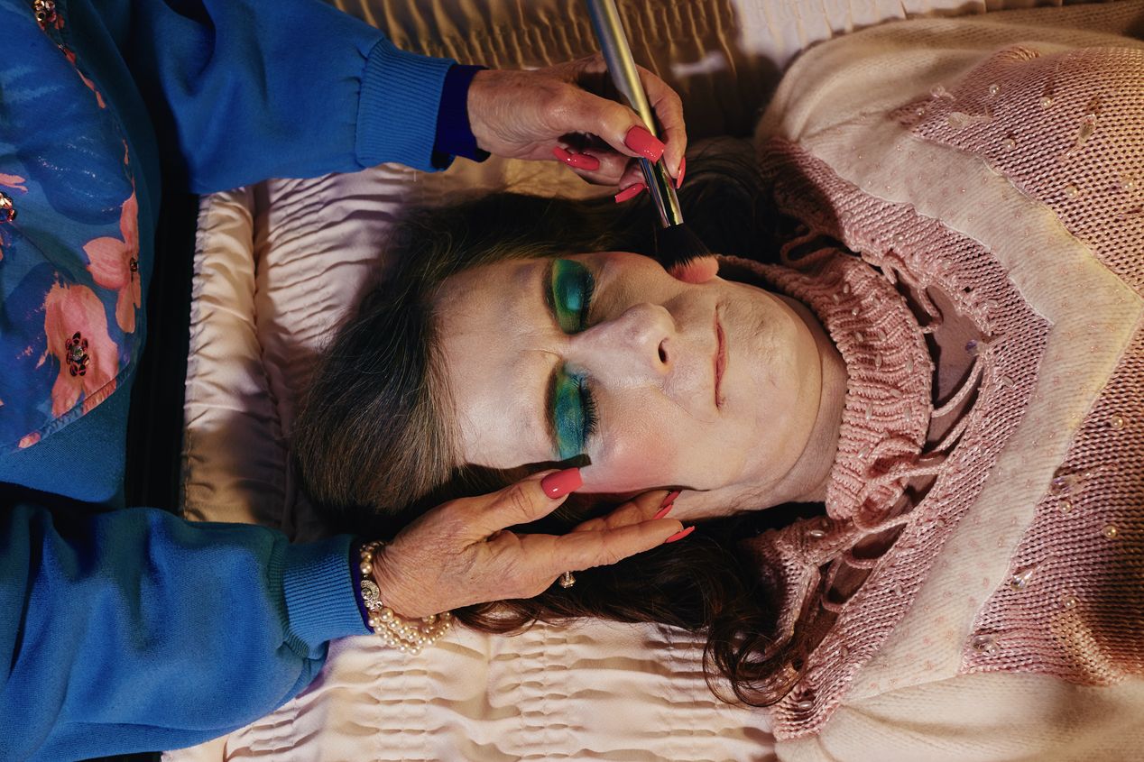 A female mortician is putting makeup on a corpse, Ilona Szwarc, Los Angeles editorial photographer.