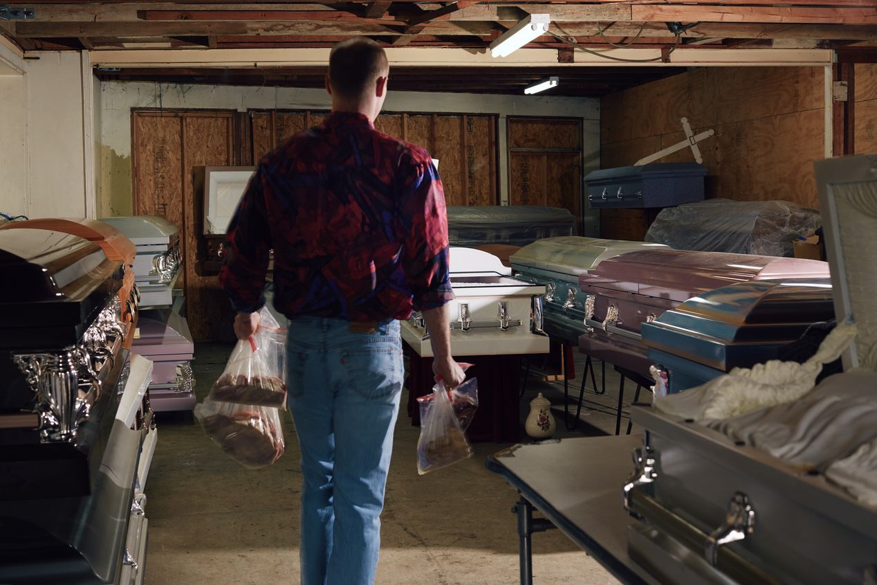 A man walking into a casket showroom, Ilona Szwarc, Los Angeles editorial photographer.