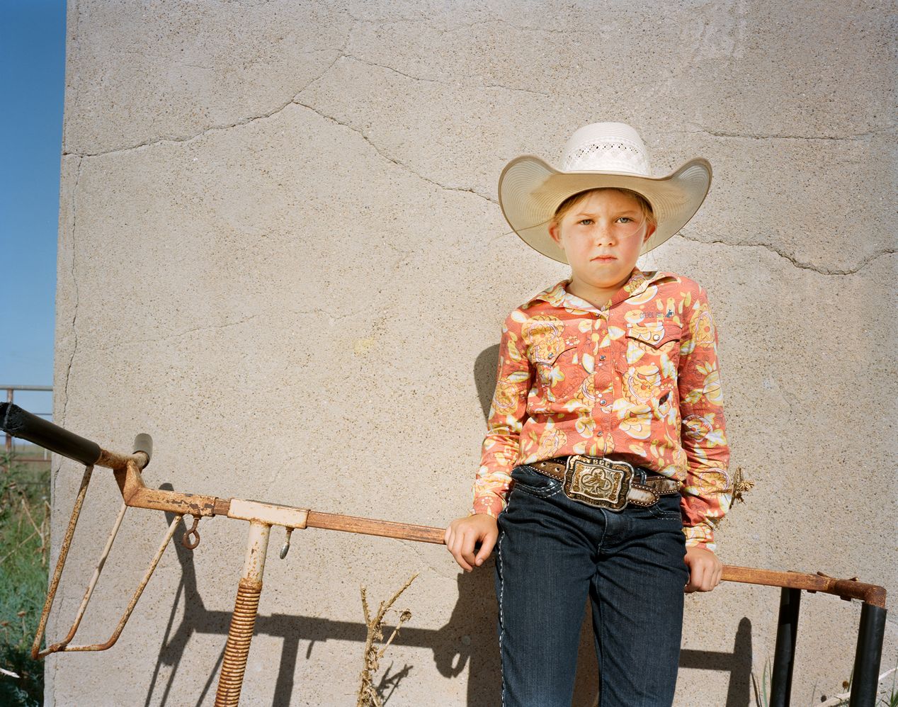 Young cowgirl leaning against a practice bull, environmental portrait photography, Ilona Szwarc, contemporary Los Angeles artist.